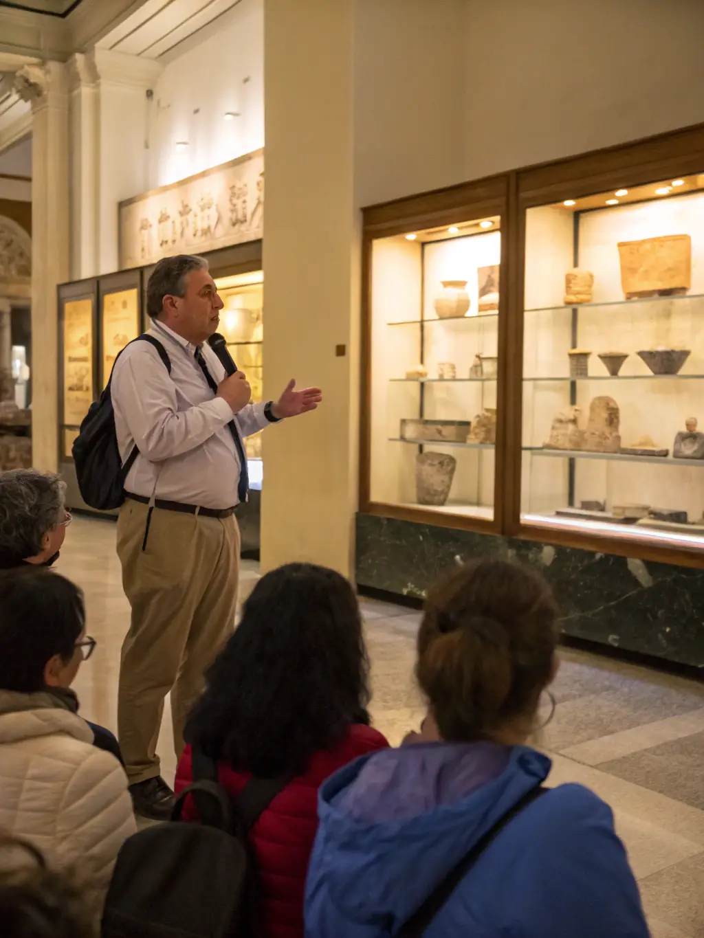 A photograph capturing a public lecture on a recent archaeological discovery in Cantal, with attendees listening attentively. The speaker is presenting findings with visual aids.